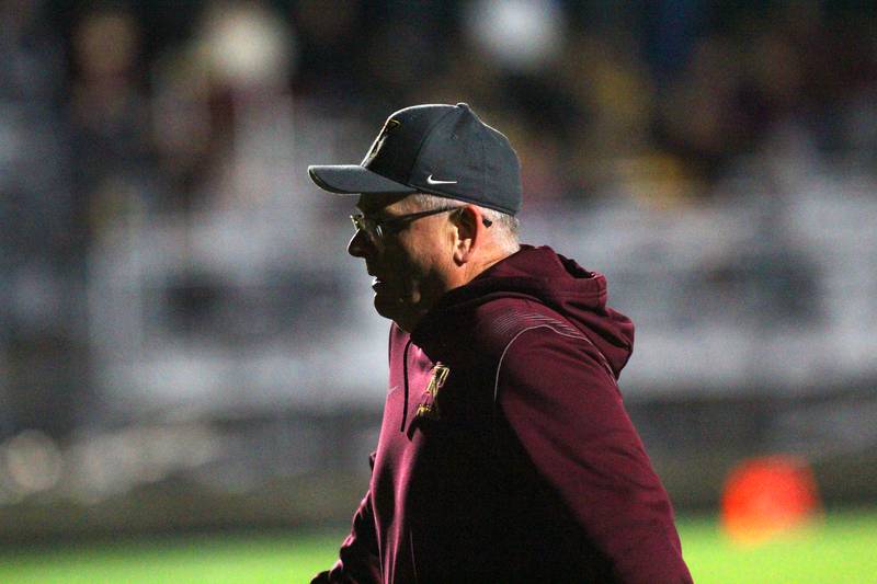 Richmond Burton’s Head Coach Mike Noll leads the Rockets on to the field for varsity football at Rod Poppe Field on the campus of Marengo High School in Marengo on Friday, Oct. 18, 2024.