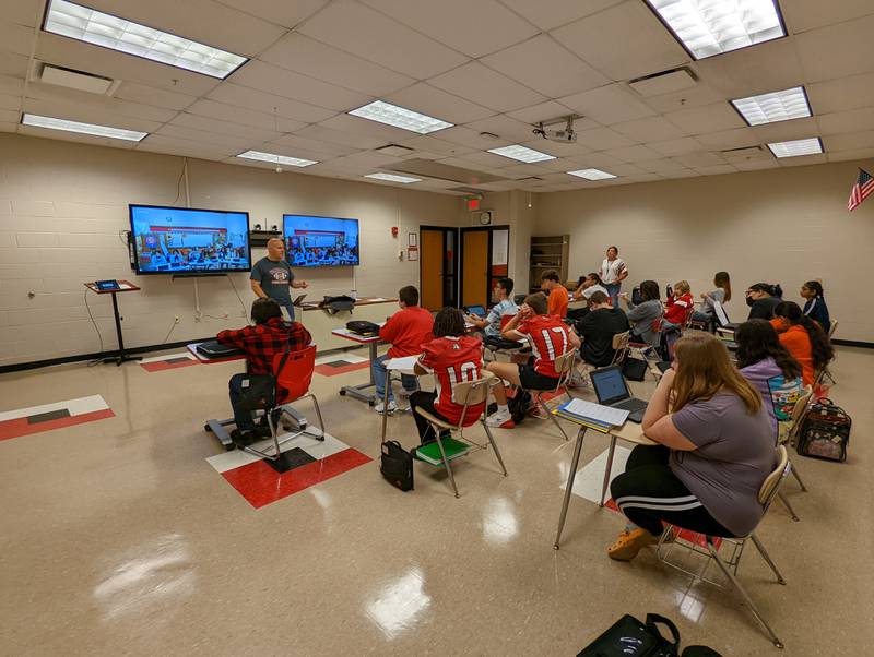 Streator High School math teacher Robb Watson leads a blended algebra class in front of high school students, and junior high students at St. Michael the Archangel Catholic School in Streator, who are participating from a video feed.