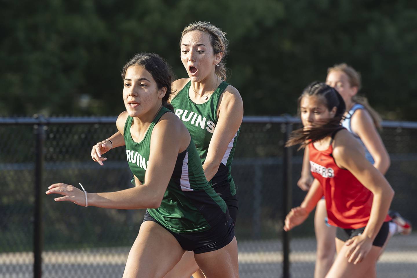 St. Bede’s Anna Lopez hands the baton to teammate Emerald De La Torre in the 4x100 Wednesday, May 10, 2023 at the class 1A Erie girls track sectional.