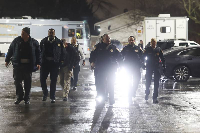 Joliet Police Chief Bill Evans (center) and other member for the Will County Sheriff and Joliet Police department leave the Will County Incident Command Center vehicle in a parking lot along West Acres Road at the scene were multiple people were found dead in two homes on Monday, Jan. 22nd in Joliet.