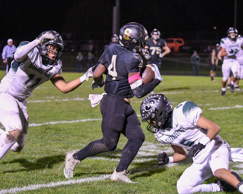 Sycamore Tyler Curtis (4) catches the ball and gets some extra yards before being brought down by a few Evergreen Park defenders on Friday Oct. 27, 2023, during the first week of play offs held at Sycamore High School.