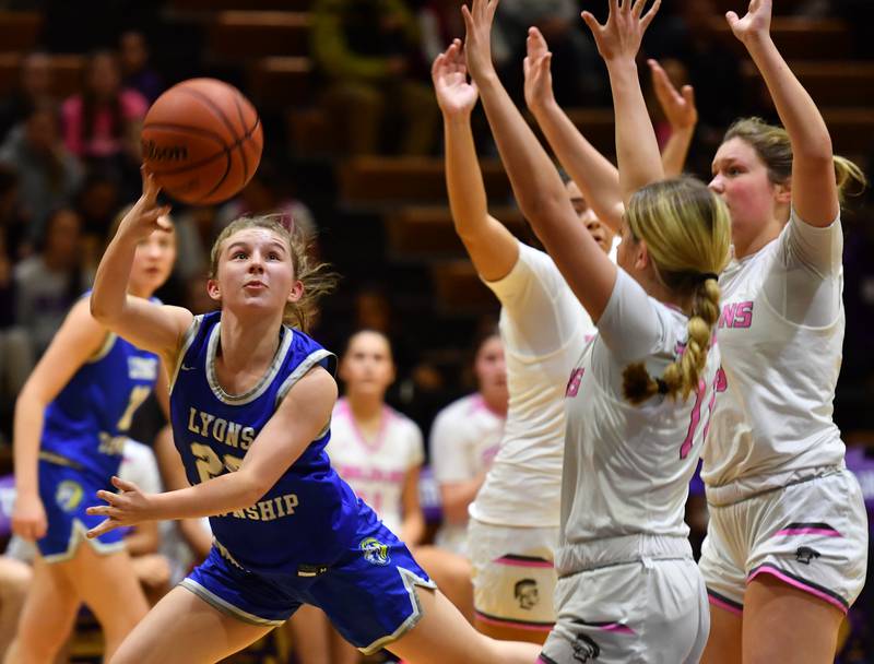 Lyons Township's Avery Mezan (left) slips past three Downers Grove North defenders to lay the ball up during a game on Jan. 30, 2024 at Downers Grove North High School in Downers Grove .