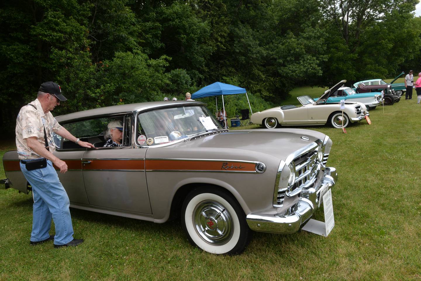 James Beymer of Henryetta, Oklahoma, visits Charlie and Maggie Wilson of Canton, Ohio, Wisconsin, as they attend the Nashional Car Show at Stronghold Camp & Retreat Center north of Oregon on Saturday, June 29, 2024. Beymer and the Wilsons both brought their 1957 Rambler Rebels to the show.