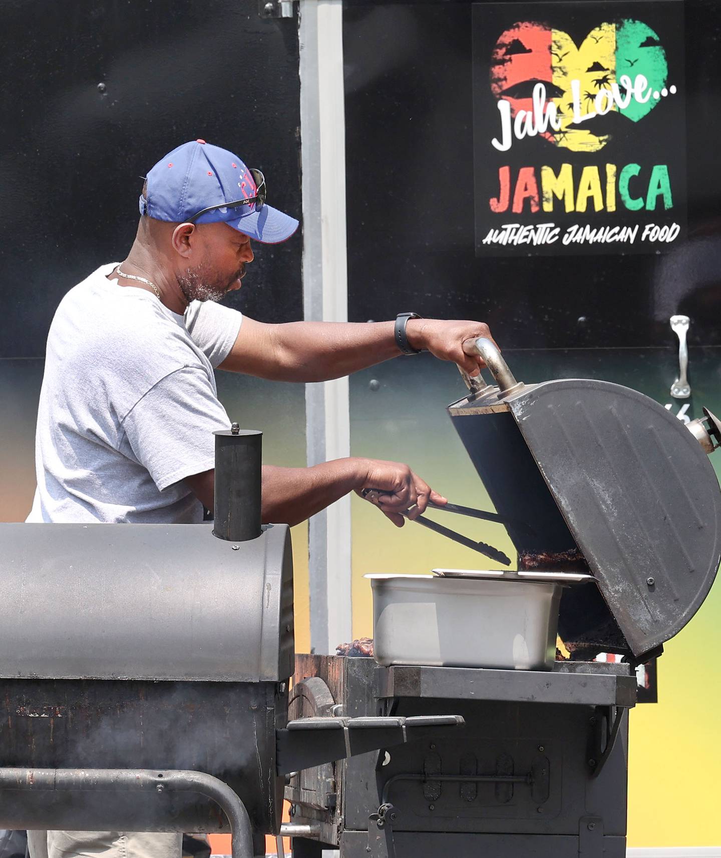 Robert Meeks cooks up some food at the Jah Love Jamaica food truck at the Juneteenth Community Celebration Sunday, June 18, 2023, at Hopkins Park in DeKalb. The event featured vendors, food, music, games, and more.