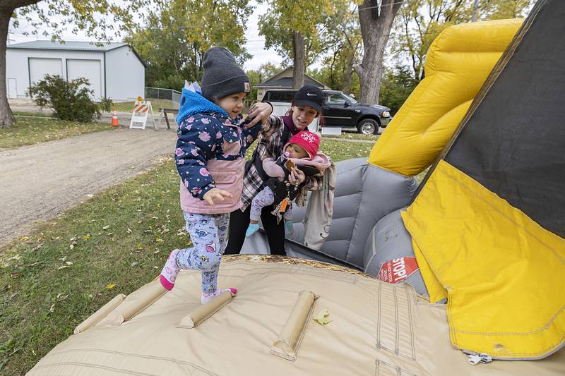 New home owner Jenna Berg helps daughter Nay’Elli, 3, into a tractor shaped bounce house Sunday for the celebration. Along with the fun things for the kids, Habitat served cookies, hot cider and gave away seeds for home gardens.