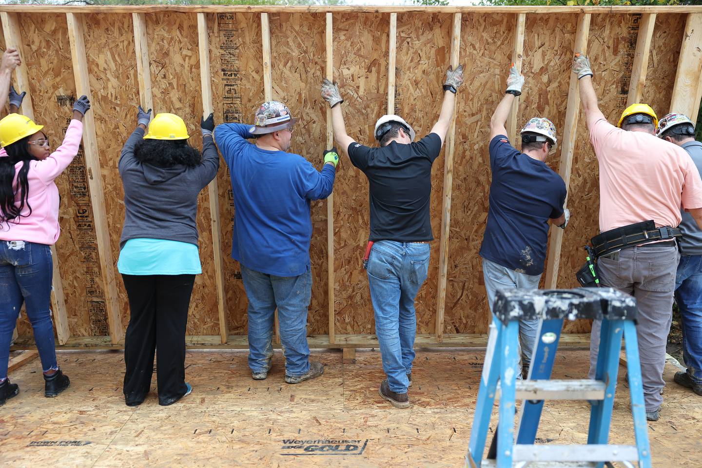 Volunteers put a wall frame in place of a home being built by Habitat for Humanity on Wednesday, Oct. 25, 2023 in Lockport.