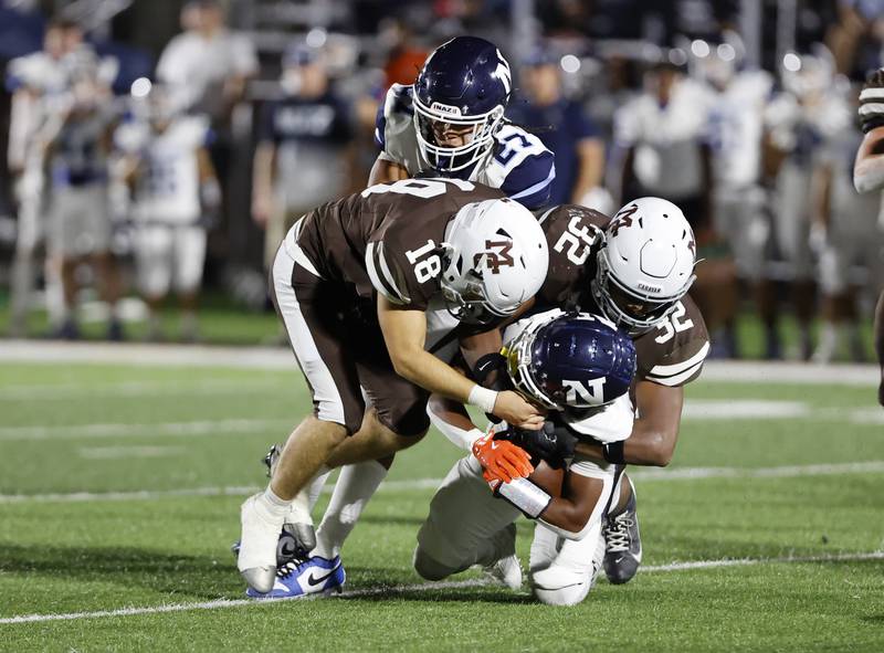 Nazareth's Edward McClain Jr. (0) is tackled by Mt. Carmel's Emmett Winters (18) and Roman Igwebuike (32) during the varsity football game between Nazareth Academy and Mt. Carmel high school on Friday, Sep. 13, 2024 in Chicago.