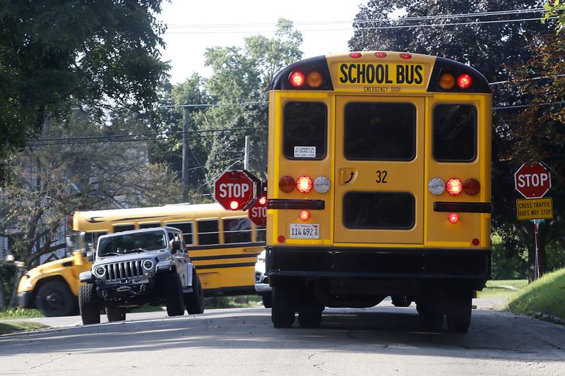 A car waits as a Woodstock school bus picks up students for the first day of school on Wednesday, Aug. 14, 2024, in Woodstock.