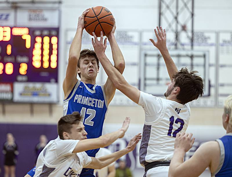 Princeton’s Tyson Phillips pulls down a rebound over Dixon’s Mason Weigle Thursday, Dec. 21, 2023 at Dixon High School.