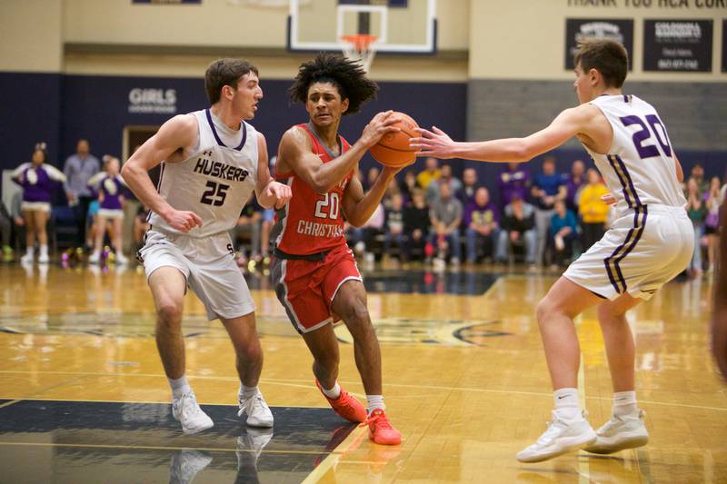 Aurora Christian's Jalen Carter drives to the basket between Serena's Richie Armour (25) and Beau Raikes (20) at the Class 1A Boy's Basketball  Super Sectional on Friday , March 1, 2024 at Harvest Christian Academy  in Elgin.