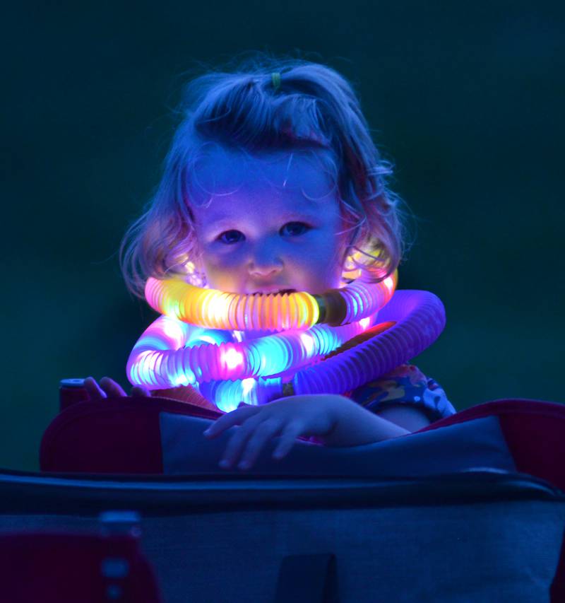 Evelyn Whalen, 2, of Oregon, wears several  glowing rings as she waits for the fireworks to start at Let Freedom Ring in Mt. Morris on Thursday, July 4, 2024.