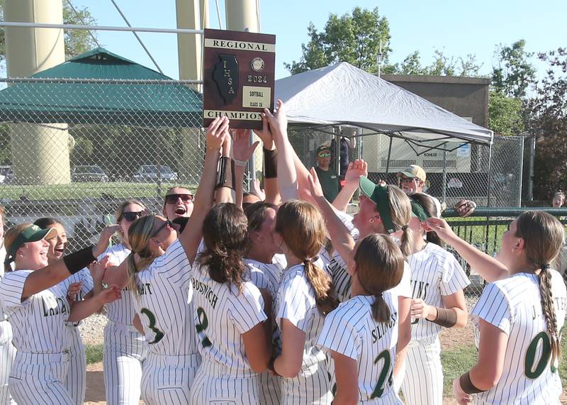 Members of the St. Bede girls softball team hoist the Class 2A Regional plaque after defeating Midwest Central on Friday, May 17, 2024 at at Abbot Phillip Davy Field.