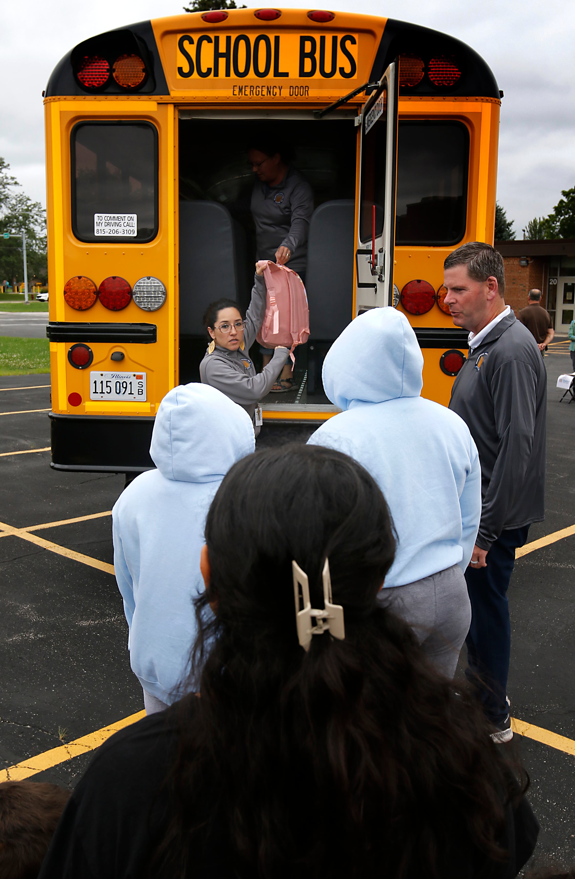 Gabi Ordonez hands out backpacks during a Woodstock School District 200 Back to School Coming to You event at Northwood Middle School on Tuesday, Aug. 6, 2024. The location was one of twelve stops on the tour that gave out backpacks and school supplies, provided registration help and computer repair.