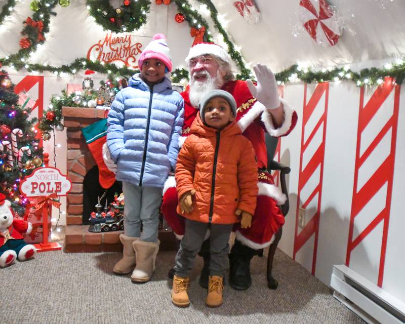 Kemiyah Holmes, 7, and Kiyon Holmes, 4, pose for a photo with Santa Claus during the DeKalb Chamber of Commerce's annual Lights on Lincoln and Santa Comes to Town event held in downtown DeKalb on Thursday, Nov. 30, 2023.