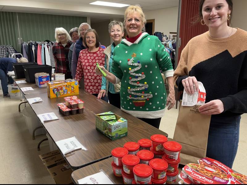 Thrivent’s Mary Toth (right), Sharon Brown (left) and volunteers for Buddy Bags program, work to put the meals together Wednesday, Dec. 14, 2022 in Dixon.