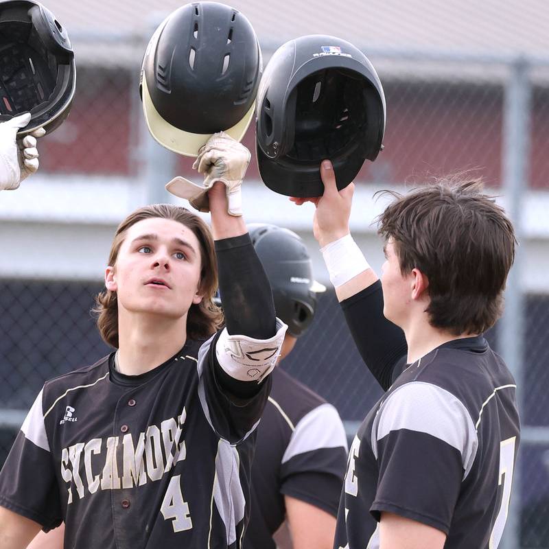 Sycamore's Collin Severson (left) is congratulated after hitting a three-run homer by teammate Sycamore's Nathan Lojko during their game against Rochelle Wednesday, April 10, 2024, at Rochelle High School.