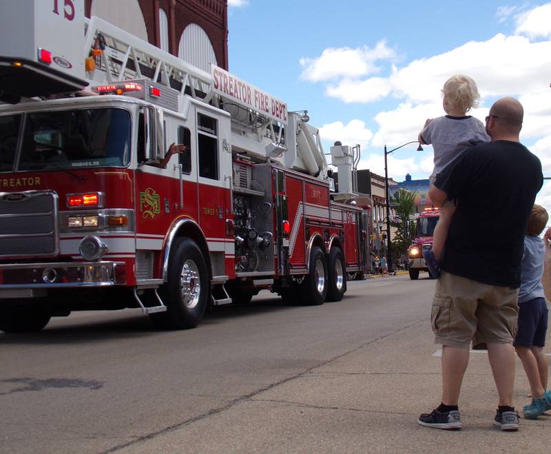 Wyatt Walker waves to fire engines Sunday, June 30, 2024, with Tommy holding him and Jon standing along side during the Liberty Fest parade in Streator.