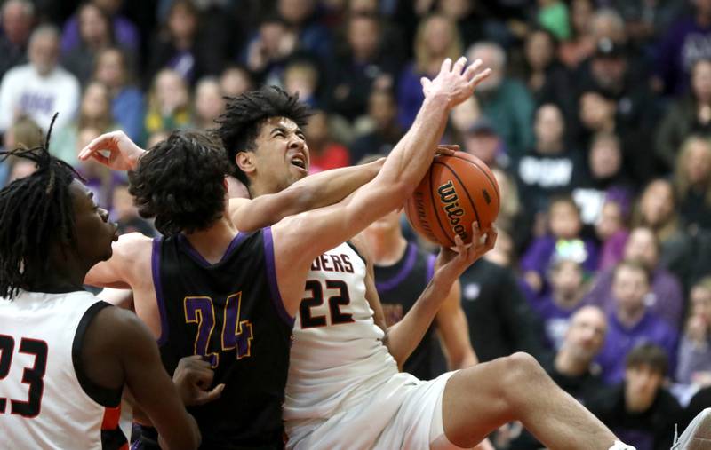 Bolingbrook’s J.T. Pettigrew (right) attempts a shot from under the basket during the Class 4A East Aurora Boys Basketball Sectional final against Downers Grove North on Friday, March 1, 2024.