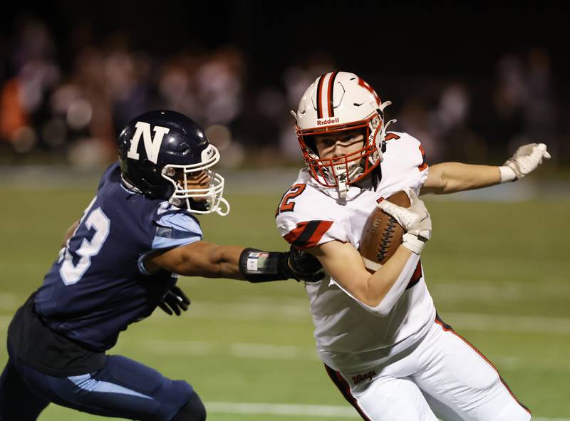 Benet's John Ericson (12) runs the ball as Nazareth's Yandiel Colon (13) closes in during the varsity football game between Benet and Nazareth academies on Friday, Oct. 18, 2024 in La Grange Park.