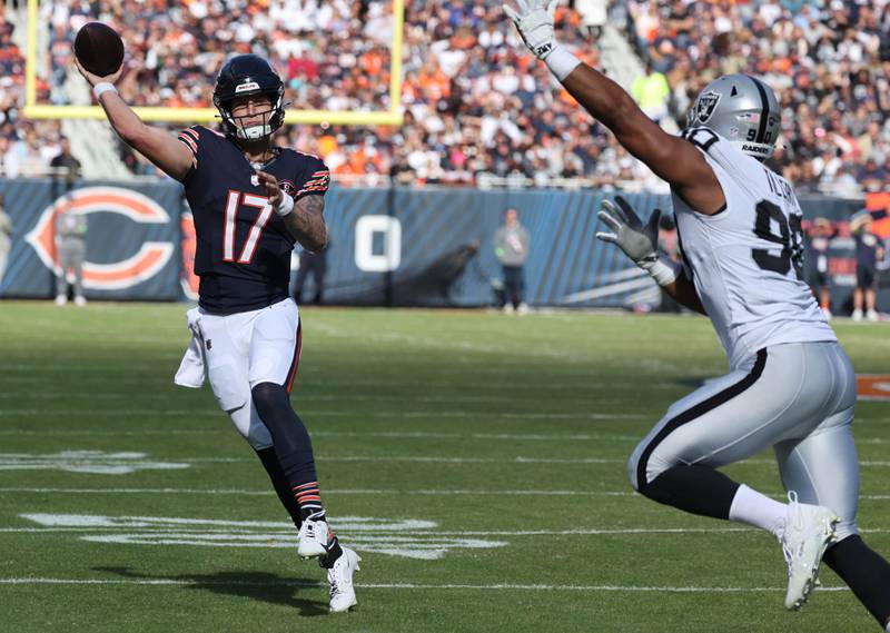 Chicago Bears quarterback Tyson Bagent throws on the run avoiding the pass rush of Las Vegas Raiders defensive tackle Jerry Tillery during their game Sunday, Oct. 22, 2023, at Soldier Field in Chicago.