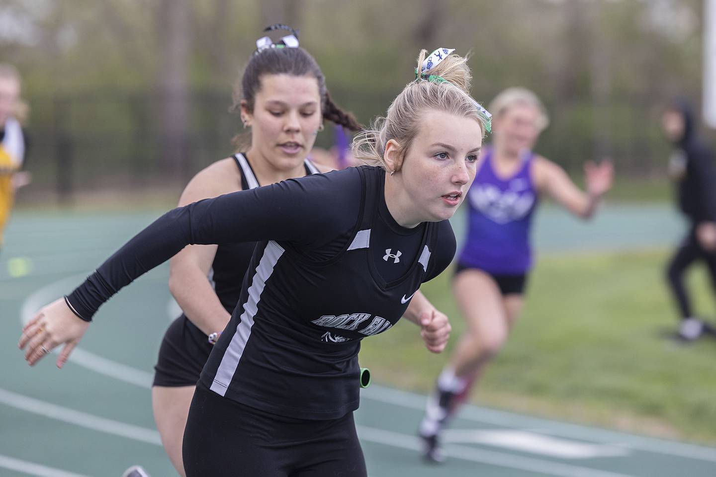 Rock Falls’ Savannah Bufford reaches back for the baton from teammate Ellisa Russell in the 4x100 Friday, April 21, 2023.