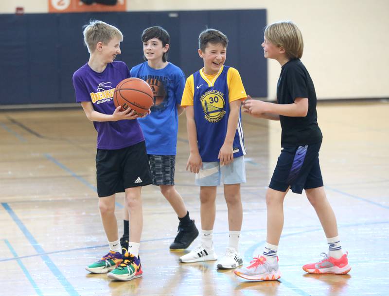 (From left) Henry Achilles, 11, Jacob Stary, 12, Nicholas Karawan, 11, and Michael Klepper, 12, play basketball during the Middle School Gym Jam at the Downers Grove Park District Recreation Center on Thursday, Jan. 4, 2024.