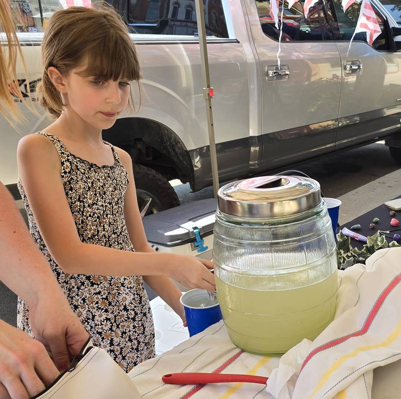 Annabelle Larabee makes an Arnold Palmer for a customer Saturday, Aug. 24, during the third annual Prairie Fox Books Children's Business Fair in downtown Ottawa.