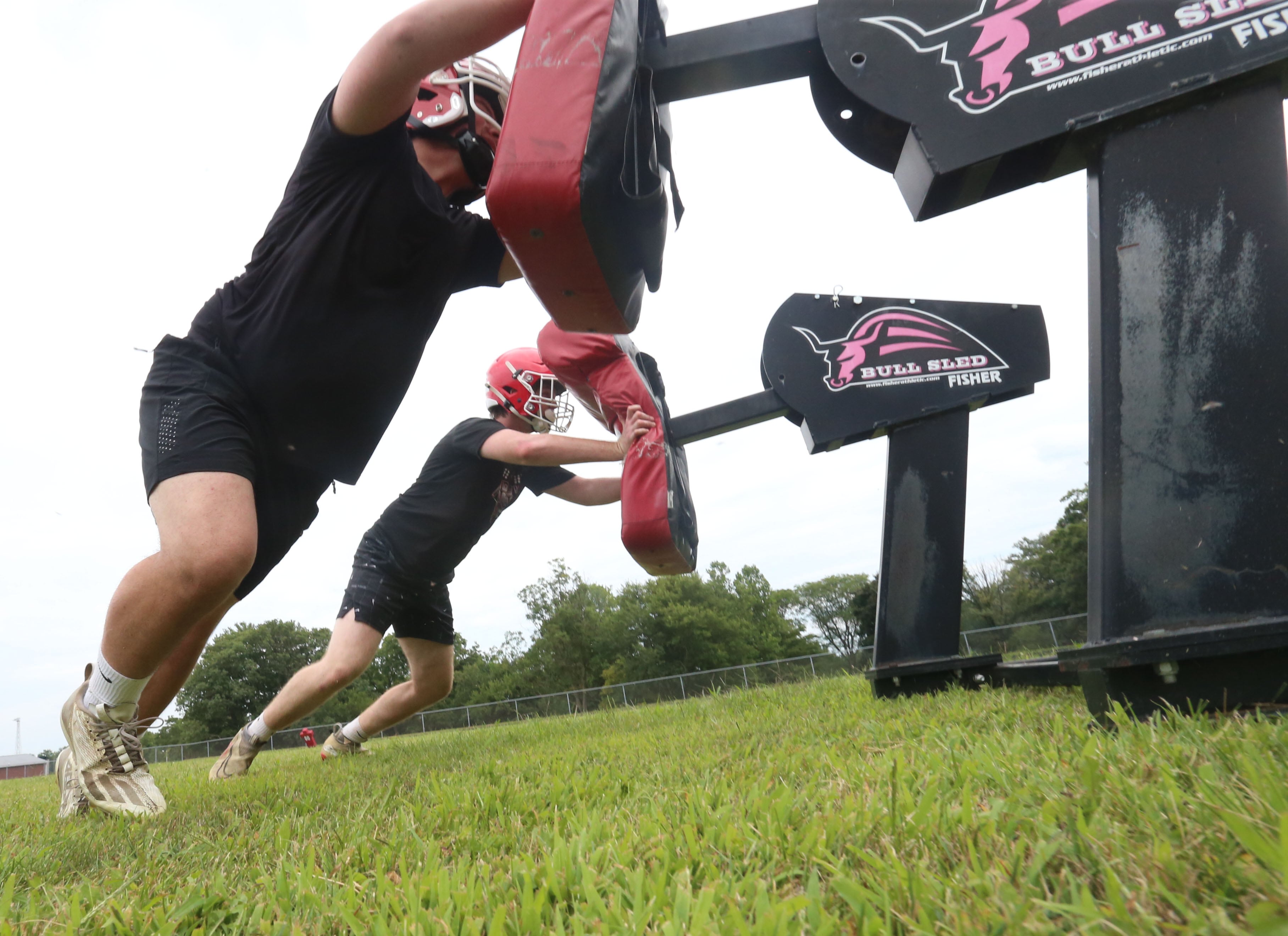 Hall's Alex Tucker and Jacob Mongon run sled drills during the first day of practice on Monday, Aug. 12, 2024 at Hall High School.