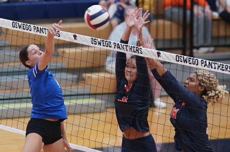 Oswego’s Ava Flanigan (12) and Maya Norlin (18) defend the net against a kill attempt by Rosary’s Reese Gilla (4) during a volleyball match at Oswego High School on Tuesday, Sep 3, 2024.