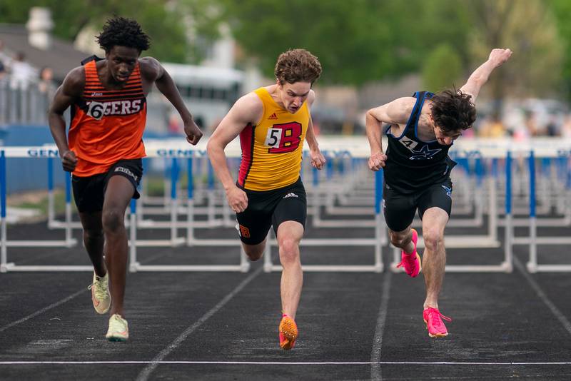 Wheaton Warrenville South’s Amari Williams (left) finishes first in the 110 meter hurdles against Batavia’s Ben Mathews (center) and St.Charles North’s Bryce Thomas (right) during a DuKane Conference boys track and field meet at Geneva High School on Thursday, May 11, 2023.