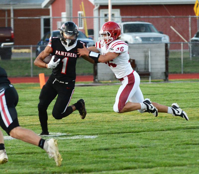 Erie-Prophetstown's Demetree Larsen (1) fights through a tackle by Hall's Johnathon Stunkel (36) during a Friday, Sept. 6, 2024 game in Prophetstown.