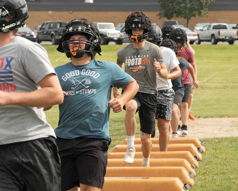 Sandwich football players step through obstacles during the first day of football practice at Sandwich High School on Monday, Aug. 12, 2024.