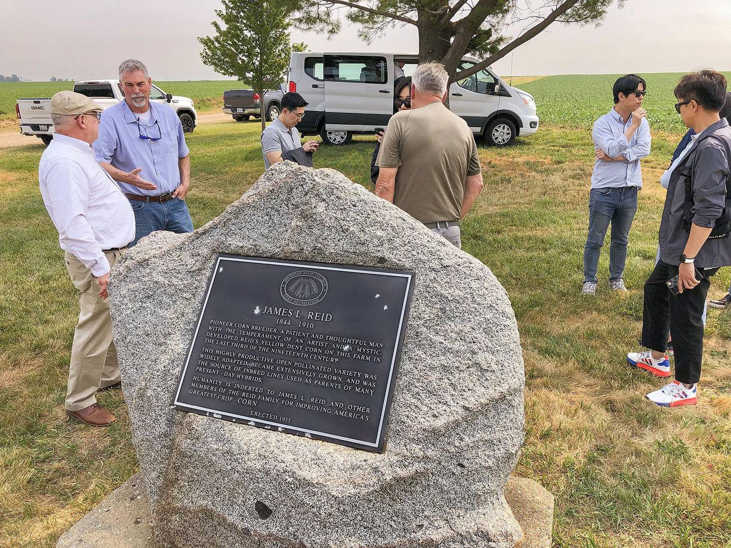Delavan natives Guy Allen (left), Kansas State University ag economist, and Matt Shipton (second from left), a seed industry representative, discuss the significance of a historical marker at the farm where Reid’s Yellow Dent Corn was developed in the 1800s. A presentation was held on the farm as part of K-State’s Grain Export and Supply Chain Expedition, hosted by Allen, that brought grain buyers from South Korea through Illinois.