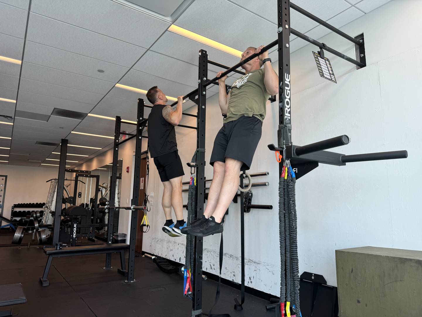 Oswego Police Chief Jason Bastin and Oswego Police Sergeant Andy Most do pull ups in the fitness room at the Oswego police station. Oswego police officers are tested on how many pull ups they can do as part of a new fitness test.