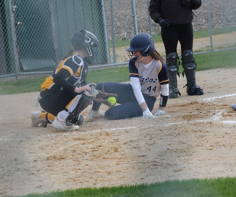 Polo's Karlea Frey slides under the throw to home to score a run as AFC catcher Lilly Carlson lays down the tag during a Tuesday, April 25 game in Ashton.