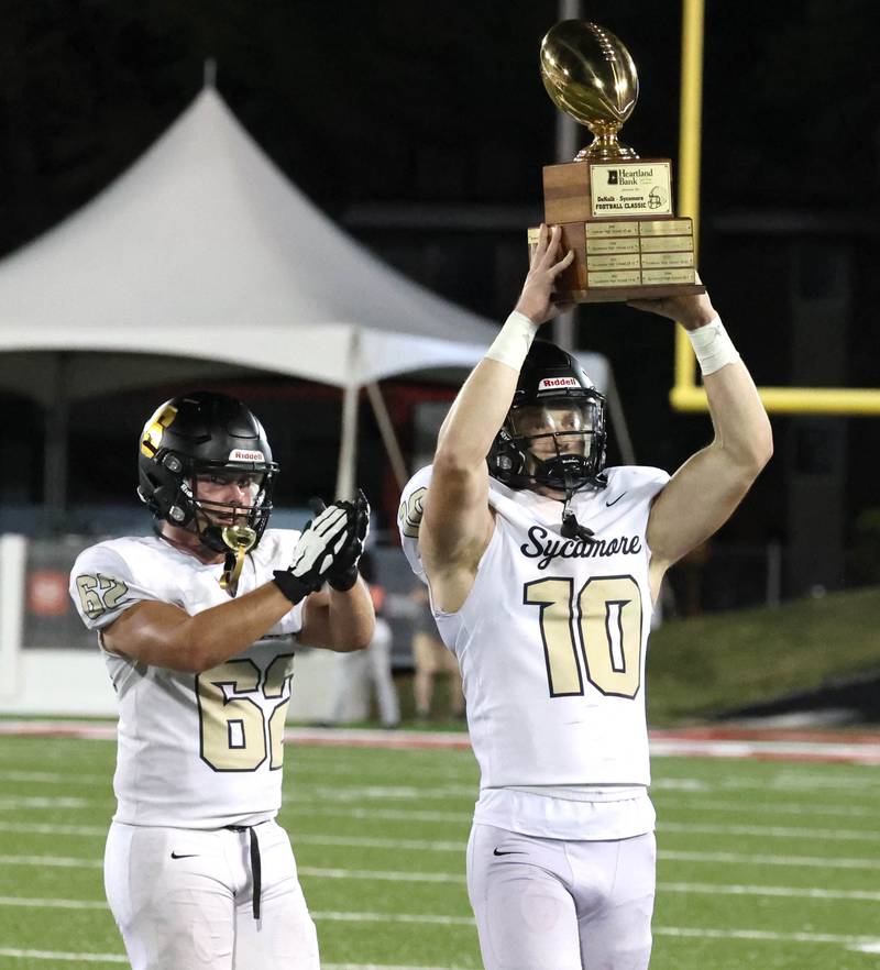 Sycamore players hoist the trophy after their win over DeKalb on a late touchdown Friday, Aug. 30, 2024, during the FNBO Challenge at Huskie Stadium at Northern Illinois University.