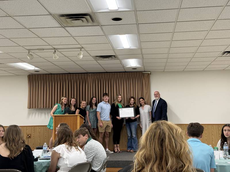 Students from Morris Community High School present representatives from the Children's Advocacy Center of Grundy County with a check for $500.