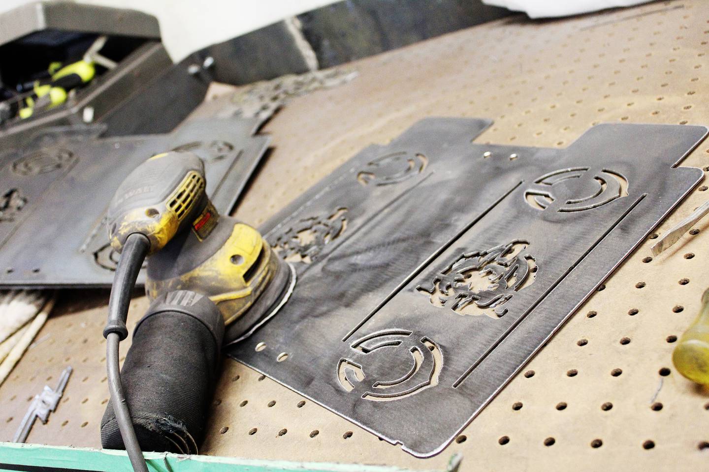 Dispensers for can Koozies are a popular product Trobey Trotter makes at his home forge. This one, with Chicago Bears logos, is awaiting cleaning by an orbital palm sander.