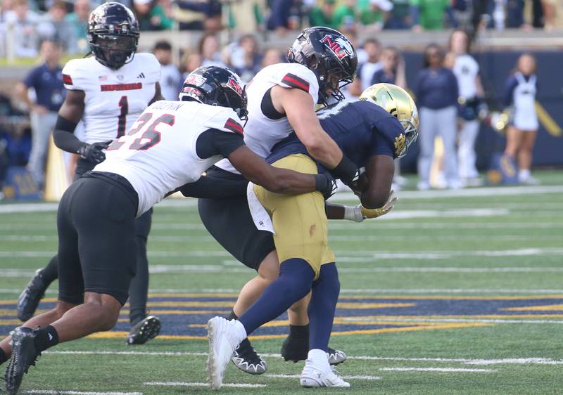 NIU's Christian Fuhrman and Jaden Dolphin bring down Notre Dame's Jeremiyah Love on Saturday, Sept. 7, 2024 at Notre Dame Stadium.