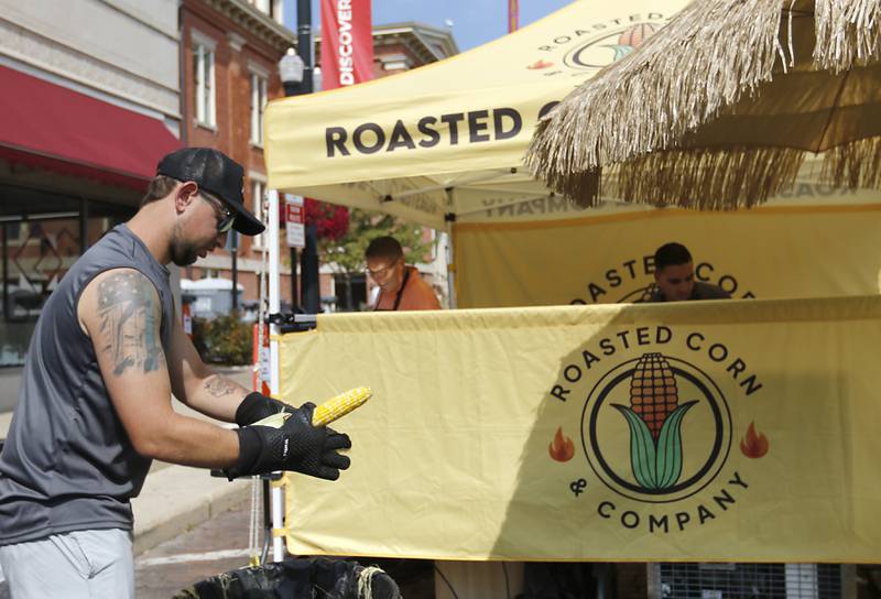 Jeremy Lewis shucks roasted corn at the Roasted Corn and Company booth during the annual Hispanic Connections Mexican Independence Day Celebration on Sunday, Sept. 15, 2024, in the Historic Woodstock Square. The celebration featured music, food and culture.