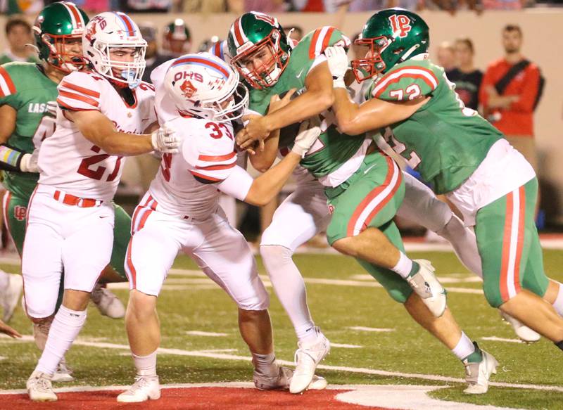 L-P's Easton Moriarity carries the ball with the help.from teammate Richard Santiago while Ottawa's Jace Veith and teammate Cody Green make the stop on Friday, Sept. 13, 2024 at Howard Fellows Stadium.