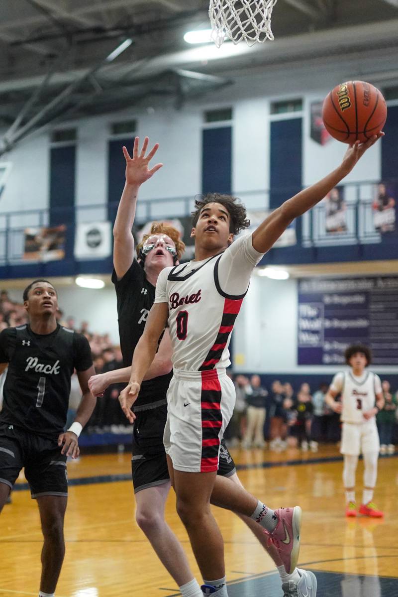 Benet’s Blake Fagbemi (0) shoots the ball in the paint against Oswego East's Andrew Pohlman (21) during a Class 4A Oswego East regional final basketball game at Oswego East High School on Friday, Feb 23, 2024.