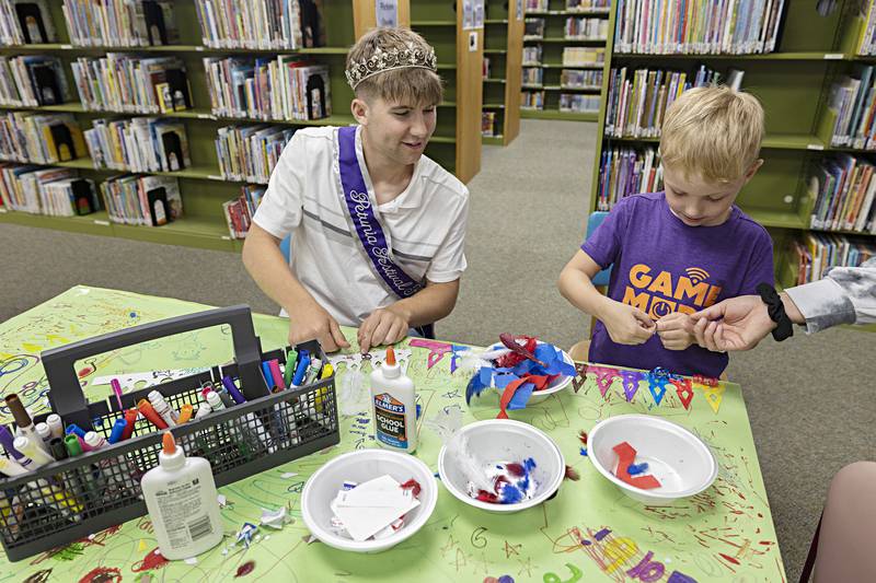 Petunia King Jonathan Harrison and Brecken Westpfahl, 6, collaborate on a decorative crown Wednesday, June 28, 2023 at the Dixon library.