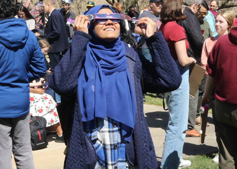 Miftahal Jannat Mokarrama, a Northern Illinois University student from Bangladesh watches the eclipse Monday, April 8, 2024, at the NIU Solar Eclipse Viewing Party behind Davis Hall in DeKalb. Attendees were treated to perfect weather to watch the rare celestial event.