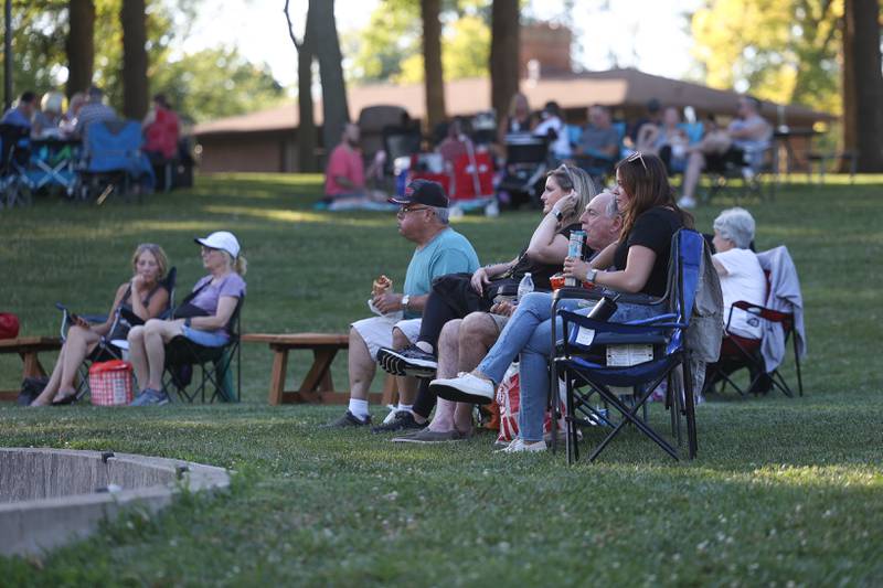People gather on the lawn to listen to live music at Dellwood Park in Lockport on Wednesday July 3, 2024.
