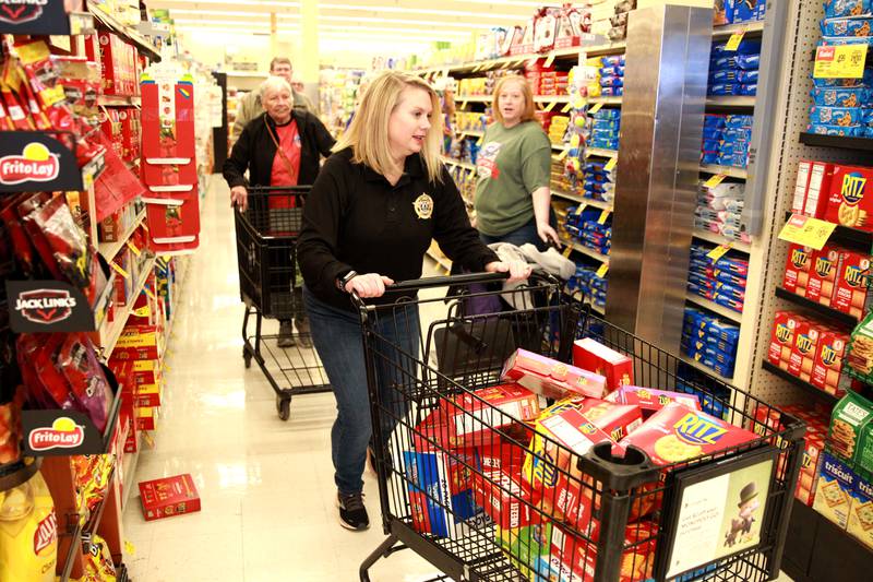 Kane County Undersheriff Amy Johnson races through the aisles for the Kane County Farm Bureau's 23rd Check Out Shopping Spree at the Jewel-Osco in Batavia on Monday, Feb. 26, 2024. Johnson collected food for Support Over Stigma of St. Charles.