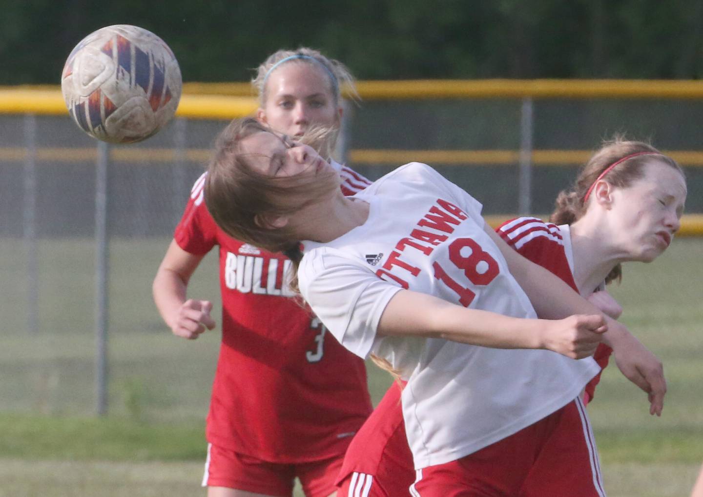 Ottawa's Chloe Carmonia (18) puts a header on the ball in fron of Streator's Bridget McGurk and Joey Puetz during the Class 2A La Salle-Peru Regional match Friday, May 10, 2024, at James Street Recreation Complex in Streator.