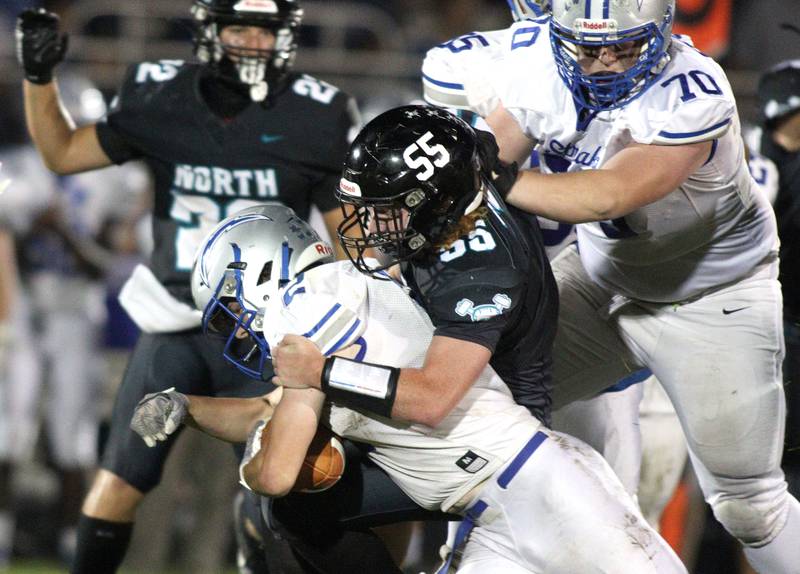 Woodstock North’s Dillon Gavers (55) tackles Woodstock’s  Maximus Miller in varsity football at Woodstock North Friday night.