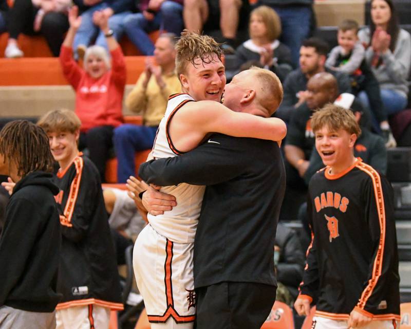 DeKalb's Sean Reynolds, left, hugs DeKalb's head coach Mike Reynolds after securing a regional title win over Auburn High School on Friday Feb. 23, 2024, held at DeKalb High School.