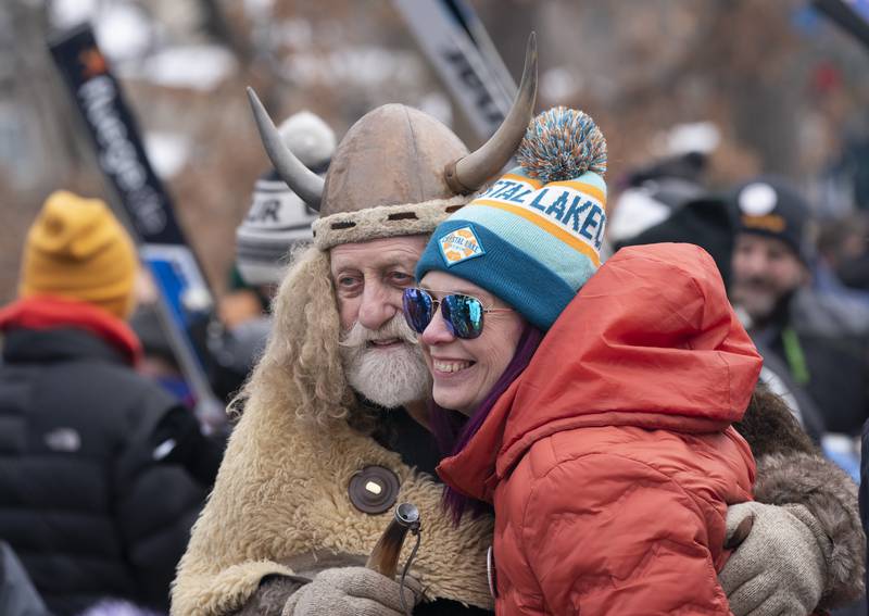 "This is the best party, so many people here it's great," said Erin Hogue, of Crystal Lake, as she gets a photo with mascot Marty the Viking during the 117th annual Norge Winter Ski Jump Tournament on Sunday, Jan. 30, 2022 in Fox River Grove.